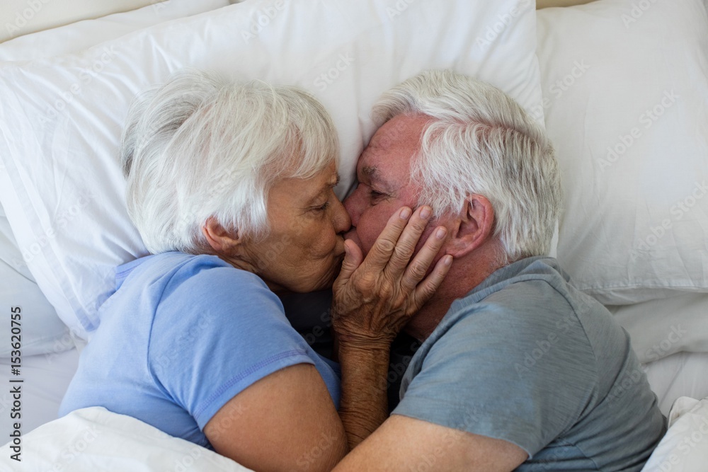 Senior couple kissing each other in bedroom Senior couple kissing each other in bedroom