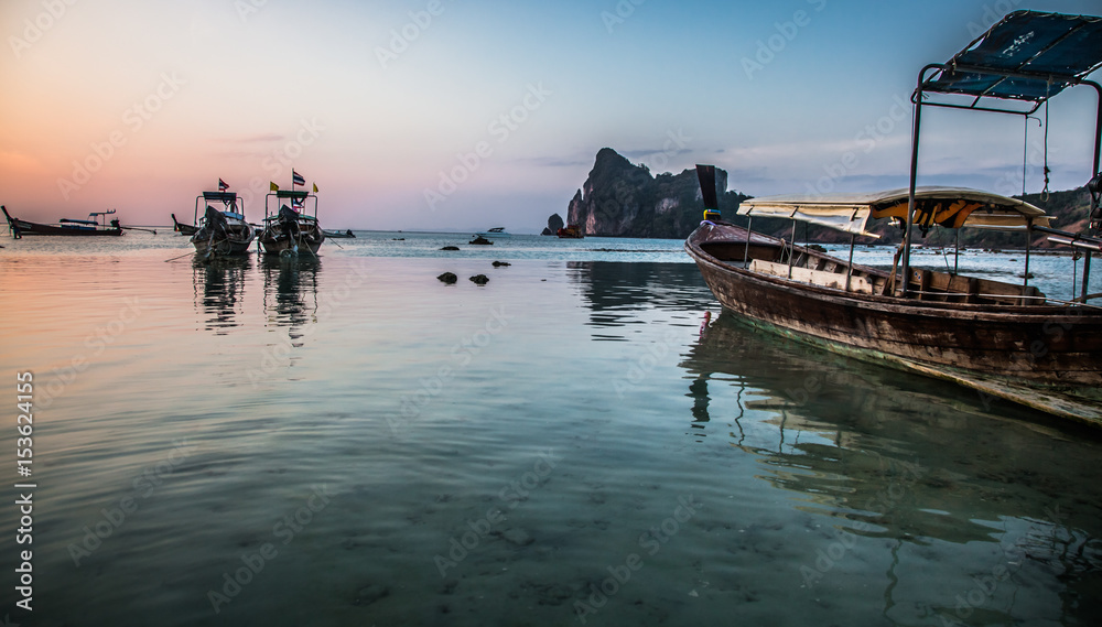 KO PHI PHI, THAILAND, January 31, 2014: Traditional long tail boats on the beach at sunset, Ko Phi Phi, Andaman Sea, famous tourist destination in Thailand