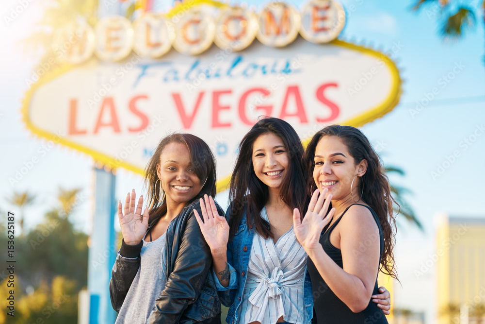 diverse all girl group of friends having at camera in front of welcome ...