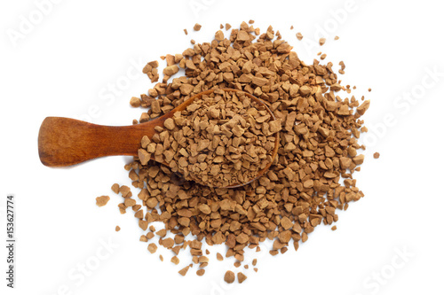 Granules of instant coffee in a wooden spoon isolated. Top view.