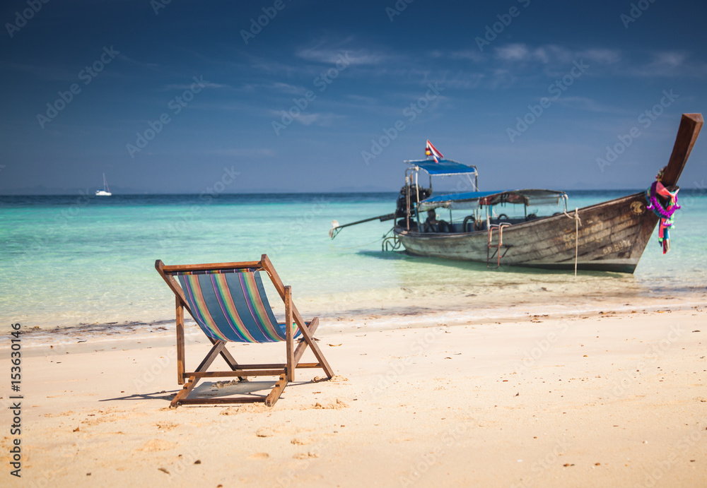 Fototapeta premium KO PHI PHI, THAILAND, February 2, 2014: Tropical beach with traditional long tail boats on the beach Mosquito island, Ko Phi Phi archiplago, Andaman Sea, famous tourist destination in Thailand