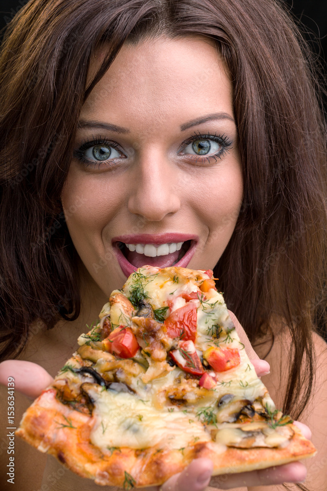 young woman with pizza against black background