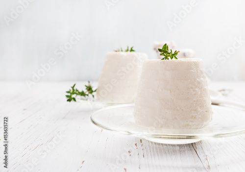 Photos Italian ricotta cheese on glass plate on light background