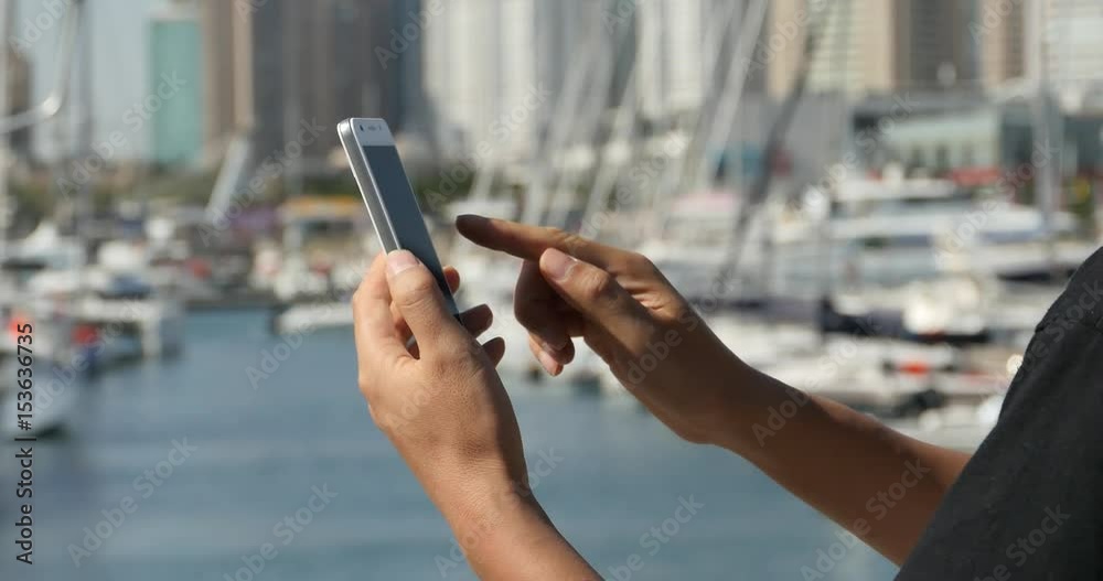 4k A girl using a smartphone at seaside,yacht & sailing in the harbour.