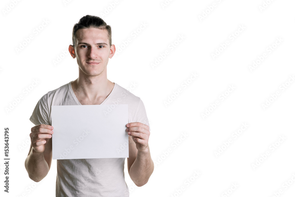 Young handsome guy with a blank sheet of paper, smiling looking into the frame. Place for signature, text. Horizontal frame Young handsome guy with a blank sheet of paper, smiling looking into the frame. Place for signature, text. Horizontal frame