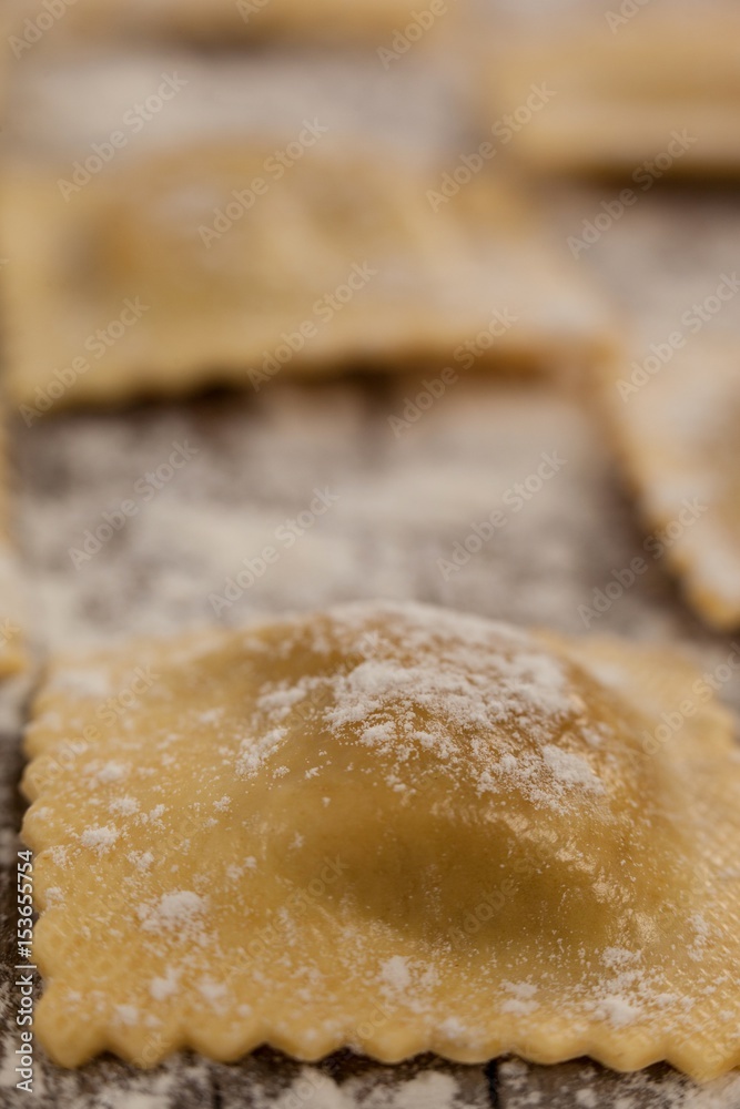 Ravioli pasta dusted with floor on wooden background Ravioli pasta dusted with floor on wooden background