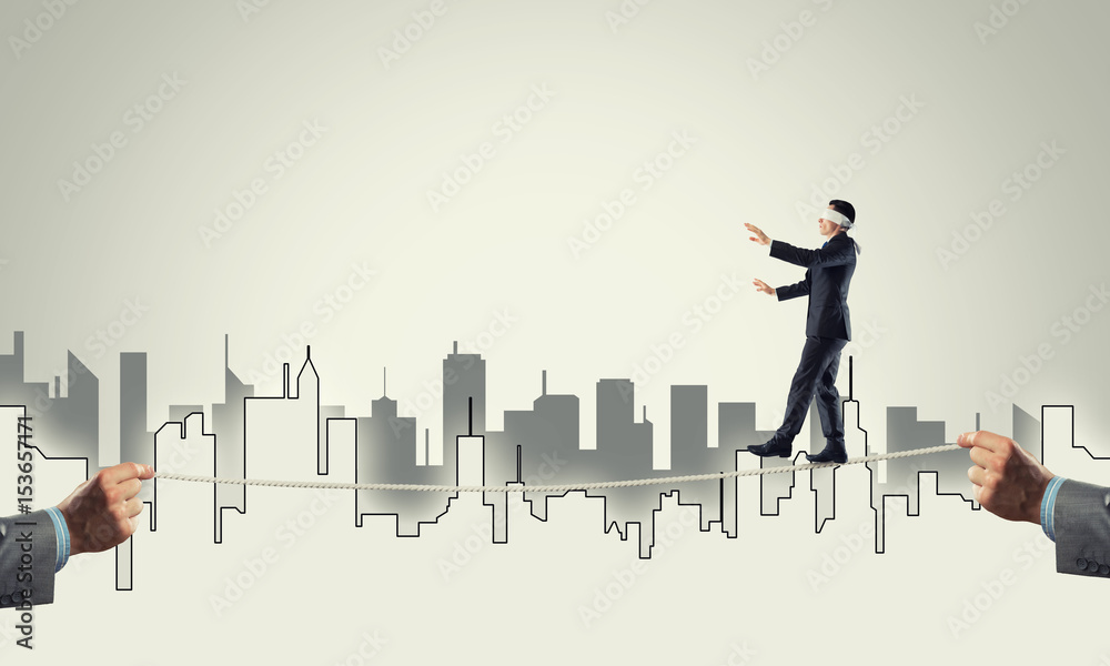 Business concept of risk support and assistance with man balancing on rope Business concept of risk support and assistance with man balancing on rope