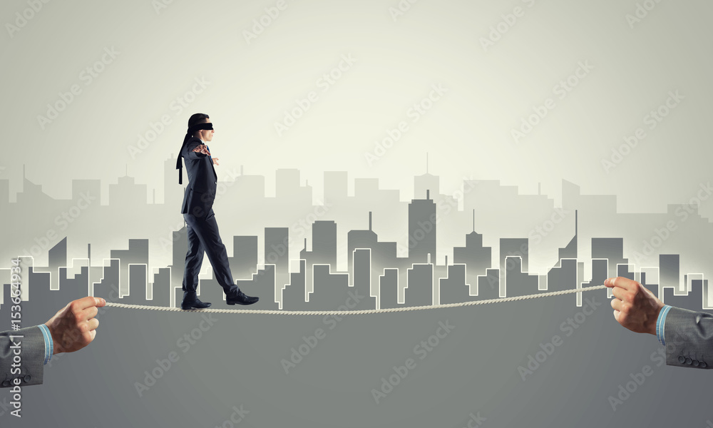 Business concept of risk support and assistance with man balancing on rope Business concept of risk support and assistance with man balancing on rope