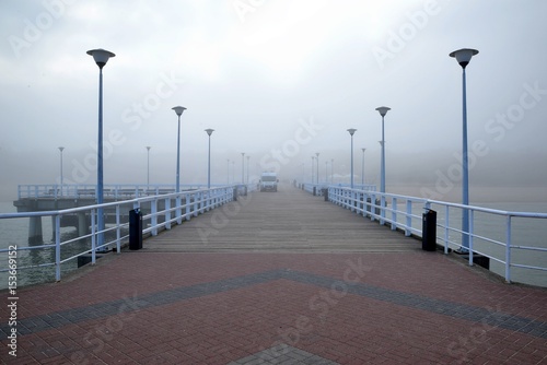 Pier overlooking the misty beach by the sea