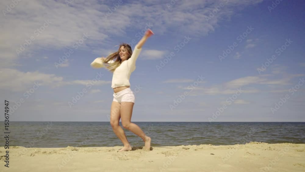 Happy girl having fun on beach. Young crazy woman playing on sea shore, dancing, jumping. Vacation happiness and craziness concept 4K ProRes HQ codec Happy girl having fun on beach. Young crazy woman playing on sea shore, dancing, jumping. Vacation happiness and craziness concept 4K ProRes HQ codec
