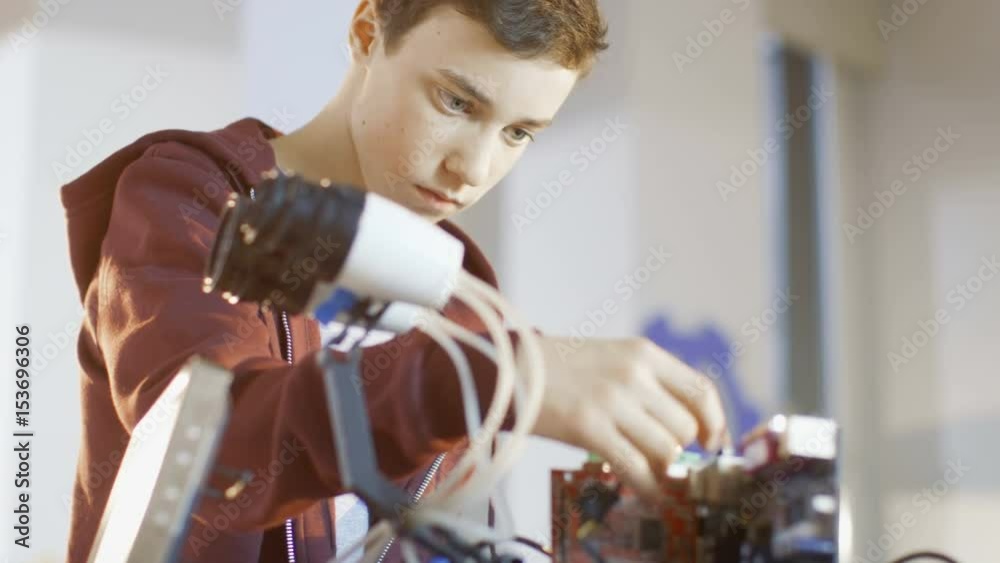 Boy Works on a Fully Functional Programable Robot with Bright LED Lights for His School Robotics Club Project. Shot on RED EPIC-W 8K Helium Cinema Camera.