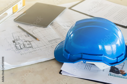 The safety helmet and the blueprint on table at construction site