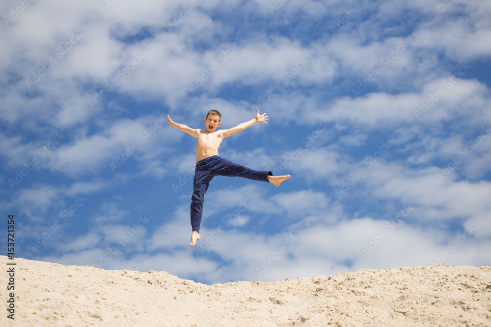 GOMEL, BELARUS - May 13, 2017: Teens study parkour on their own. Acrobatics in the sand. GOMEL, BELARUS - May 13, 2017: Teens study parkour on their own. Acrobatics in the sand.