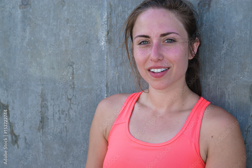 Young woman resting on wall after exercising Young woman resting on wall after exercising