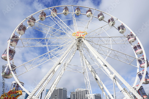 close up white ferris wheel with cloudy blue sky taken at Darling Harbour in Sydney Australia on 6 July 2016
