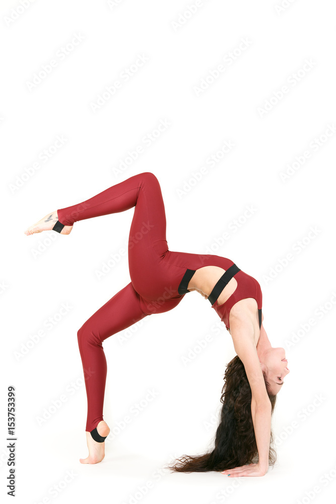 Looks easier than it is! Full length shot of a gorgeous fit woman standing in the bridge position with her leg raised practicing gymnastics