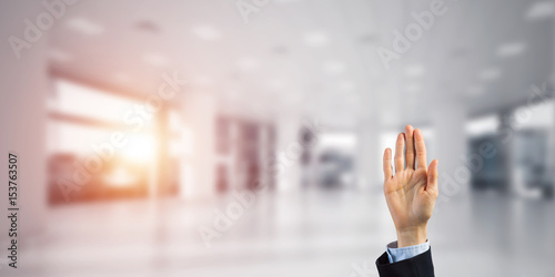 Choosing gesture of businessperson in elegant modern interior in sunshine light