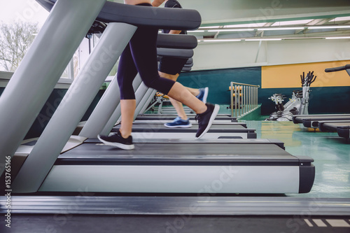 Close up of people legs running over treadmill in a training session on fitness center
