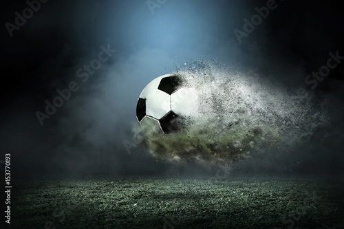 Moving soccer ball around splash drops on the stadium field.