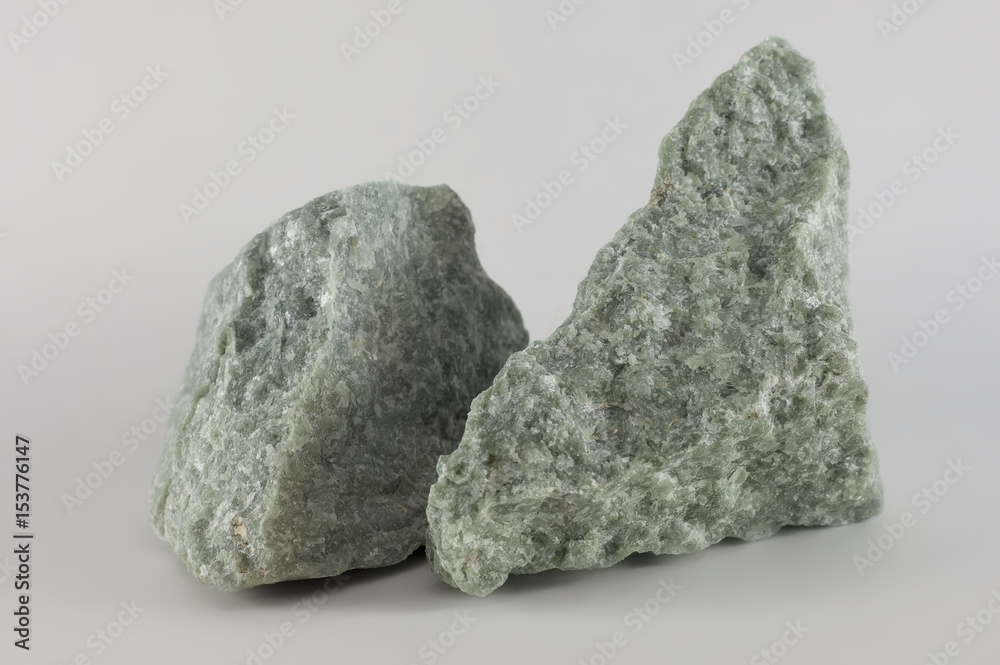 Close-up of two raw jade mineral stones, isolated on white background Close-up of two raw jade mineral stones, isolated on white background