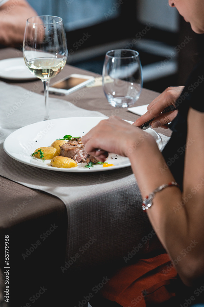 woman eating delicious roulade of rabbit meat in a restaurant. small portion woman eating delicious roulade of rabbit meat in a restaurant. small portion