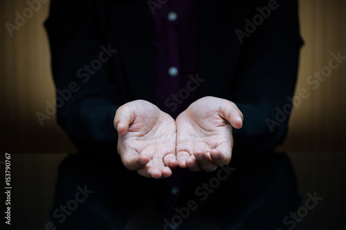 Schilderij op canvas Businesswoman showing empty handed outstretched palm at desk
