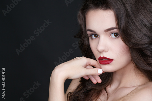 Playful and charming. Studio portrait of an attractive model wearing elegant classic make up against black background copyspace on the side.