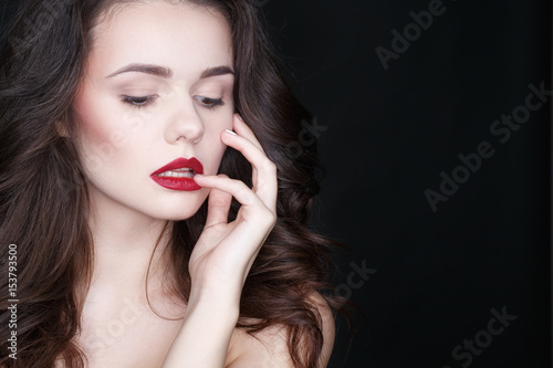 Wonder to behold. Studio shot of a young hot female posing touching her lips on black background.