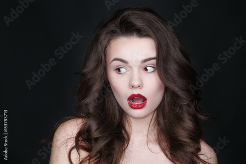 OMG! Studio shot of a young lovely female looking shocked at the copyspace on black background.