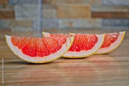 Closeup of grapefruit wedges on a wooden table