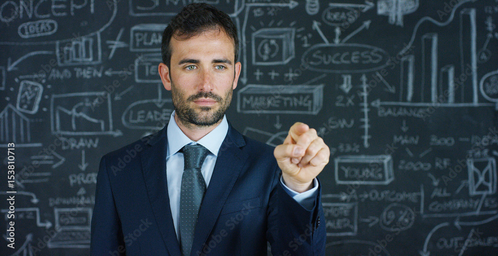 Portrait of a business man, a marketing teacher, draws a graph of success on a black board, on a black background. The concept: career growth, growth chart, successful man, marketing, ideas, finance. Portrait of a business man, a marketing teacher, draws a graph of success on a black board, on a black background. The concept: career growth, growth chart, successful man, marketing, ideas, finance.