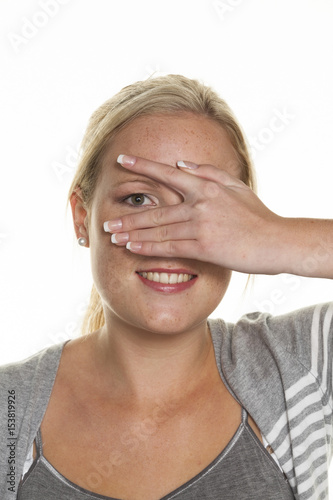 woman looking through fingers of her hand