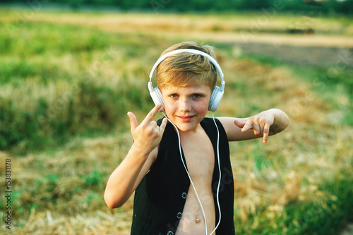 portrait of a boy with headphones on the background of nature