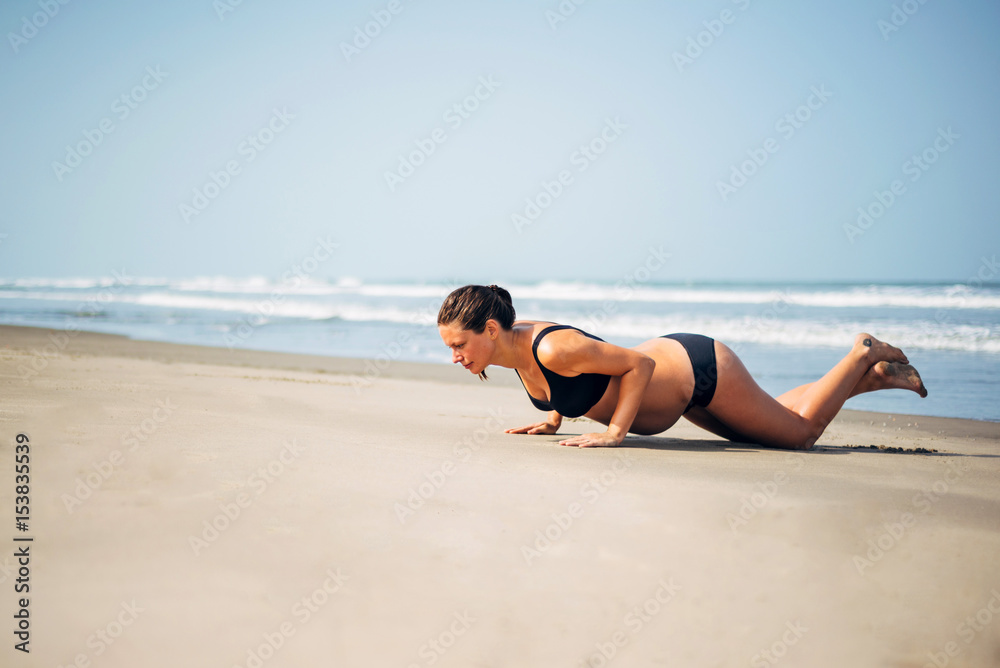 Pregnant woman on the beach doing yoga. Pregnant woman doing workout near the the sea. Pregnant woman on the beach doing yoga. Pregnant woman doing workout near the the sea.