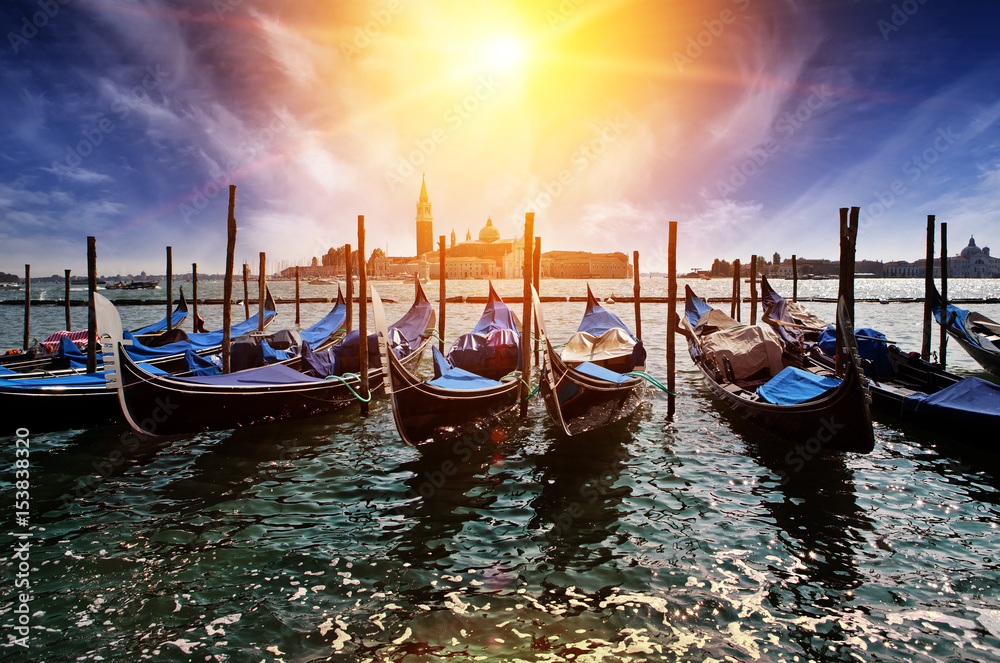 Venice. A sunset over the channel Grande and gondolas at the mooring..