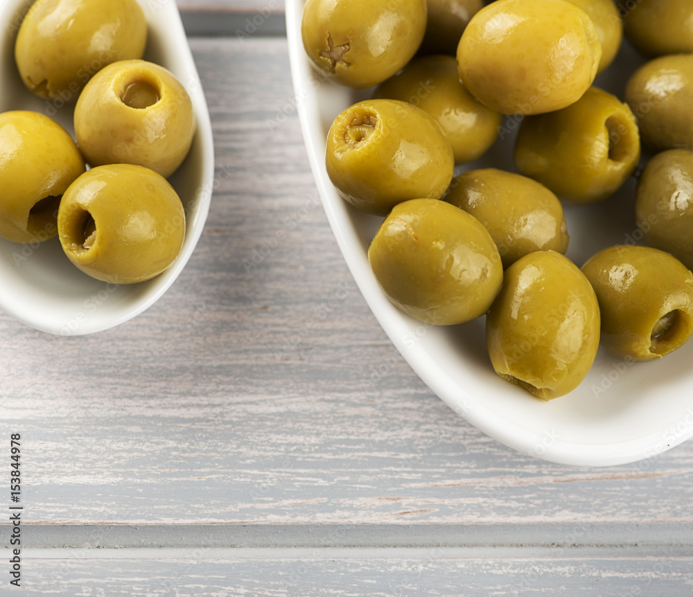 Stuffed olives on ceramic containers on wooden table. Copy space. Stuffed olives on ceramic containers on wooden table. Copy space.