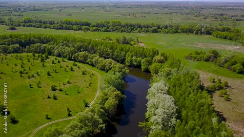 Flight over the Seim River, Ukraine surrounded by trees - aerial videotaping photo