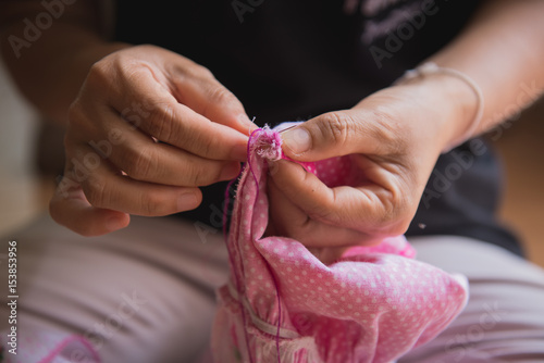 Woman s hand sewing fabric with sewing equipments