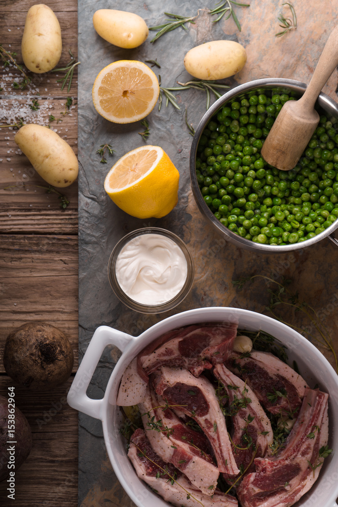 Ribs of lamb, potatoes, lemon, peas on slate Ribs of lamb, potatoes, lemon, peas on slate