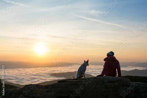 Girl and her dog relaxing on a peak © catgrig