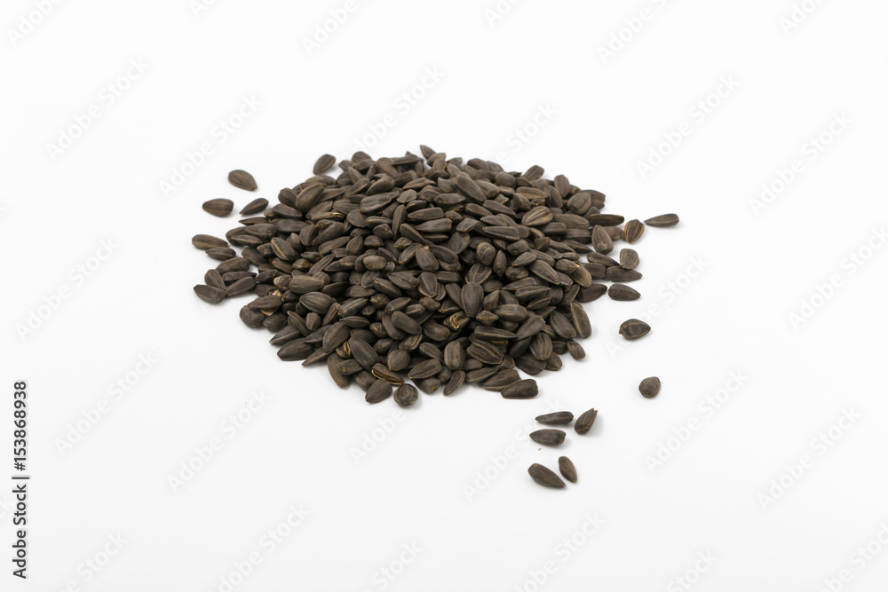 Black fried sunflower seeds on a white background. Black fried sunflower seeds on a white background.
