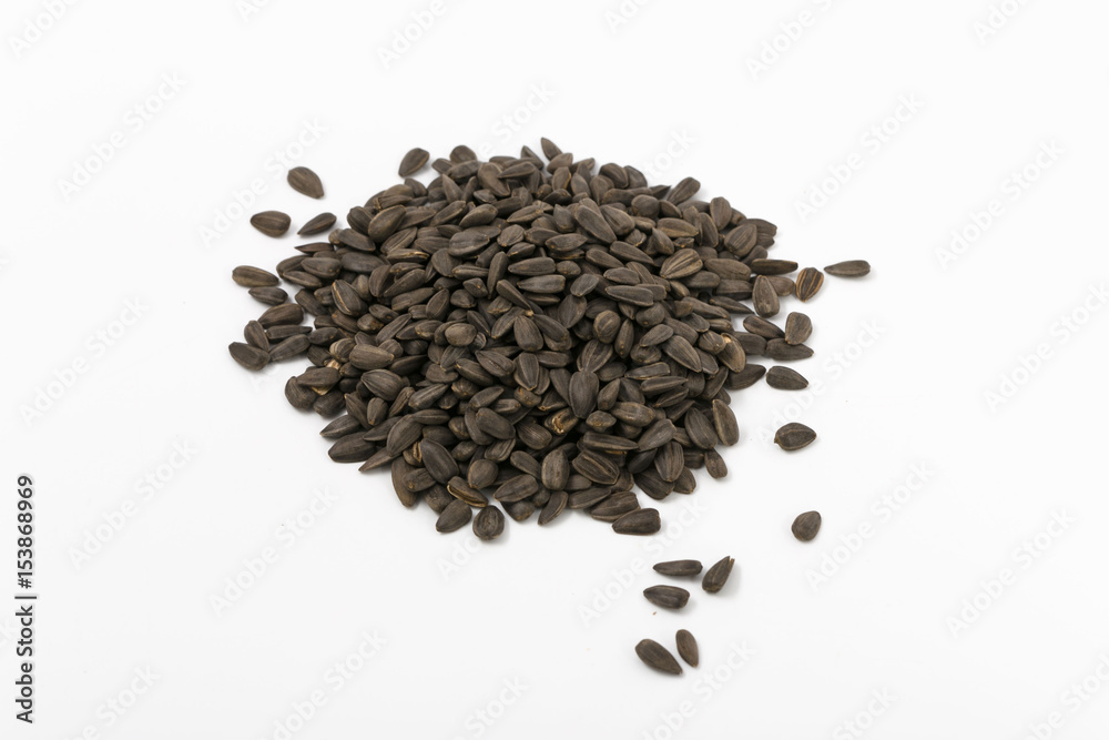 Black fried sunflower seeds on a white background. Black fried sunflower seeds on a white background.