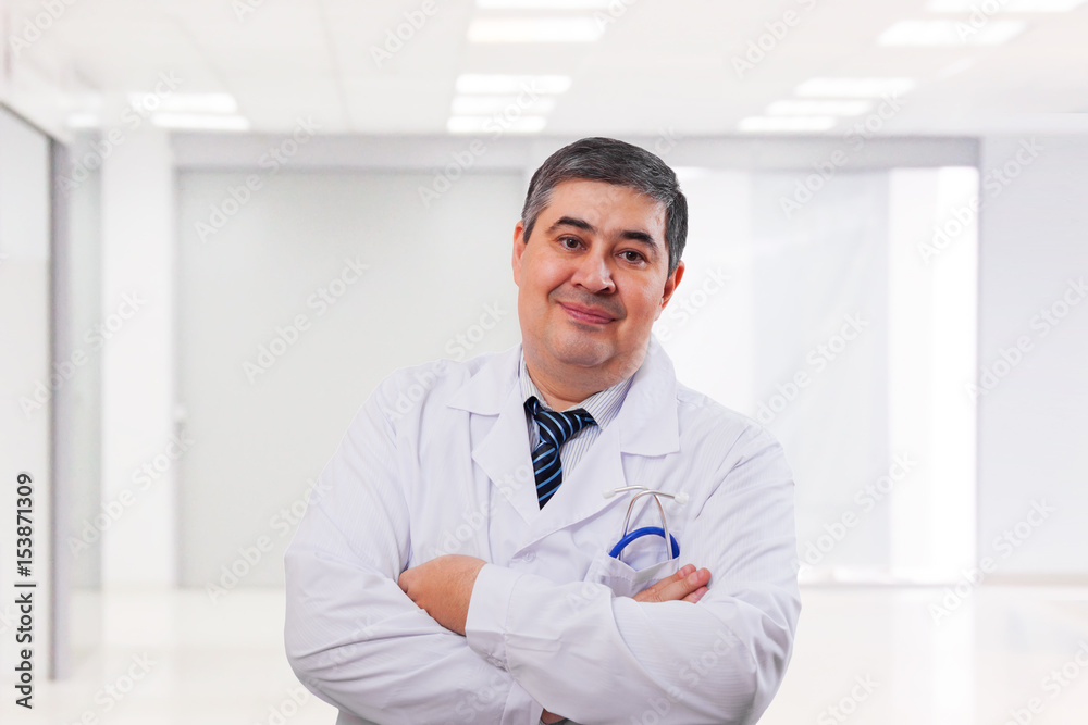 Portrait of a male doctor over clinic background Portrait of a male doctor over clinic background