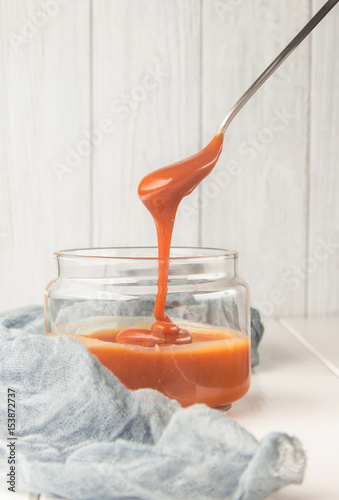 Salted caramel in a jar, dessert spoon, selective focus, vertical
