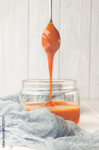 Salted caramel in a jar, dessert spoon, selective focus, vertical
