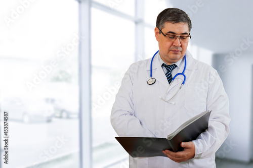 A doctor in is reading a diagnosis