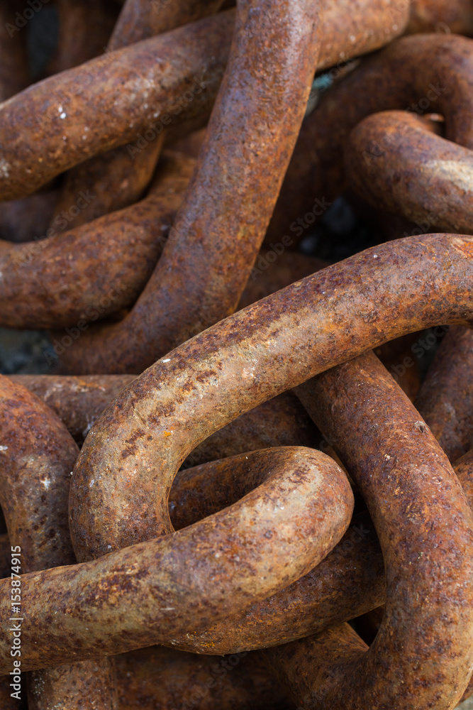 A full frame image of thick, heavy industrial chains that are rusty, weather and worn an industry background image. A full frame image of thick, heavy industrial chains that are rusty, weather and worn an industry background image.