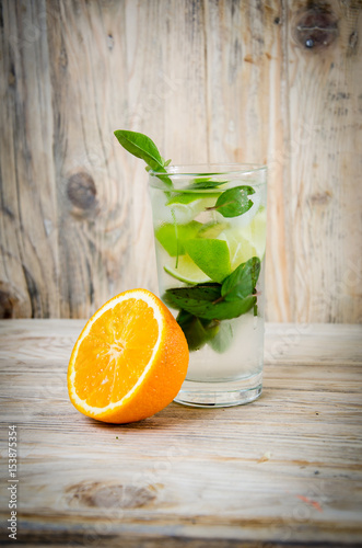 Fresh lemonade drink with ice. Fruit. Orange and green mint leaves