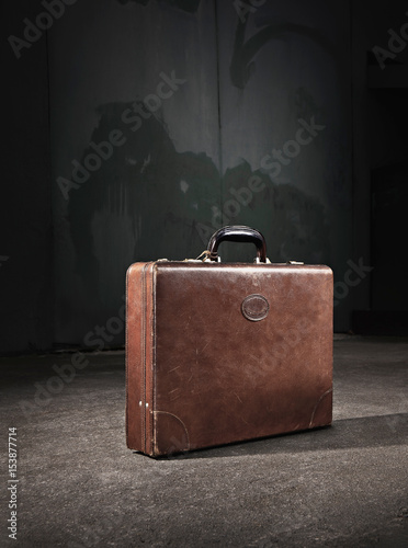 Leather suitcase abandoned on street photo