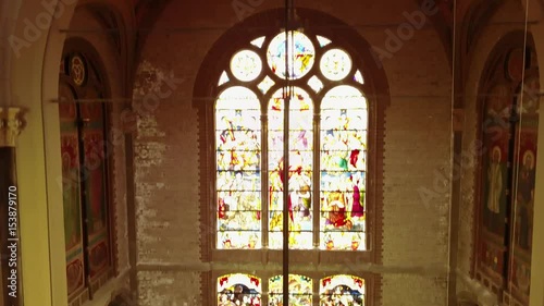 Flying down from the dome of a church along the stained glass to the altar- 4K photo